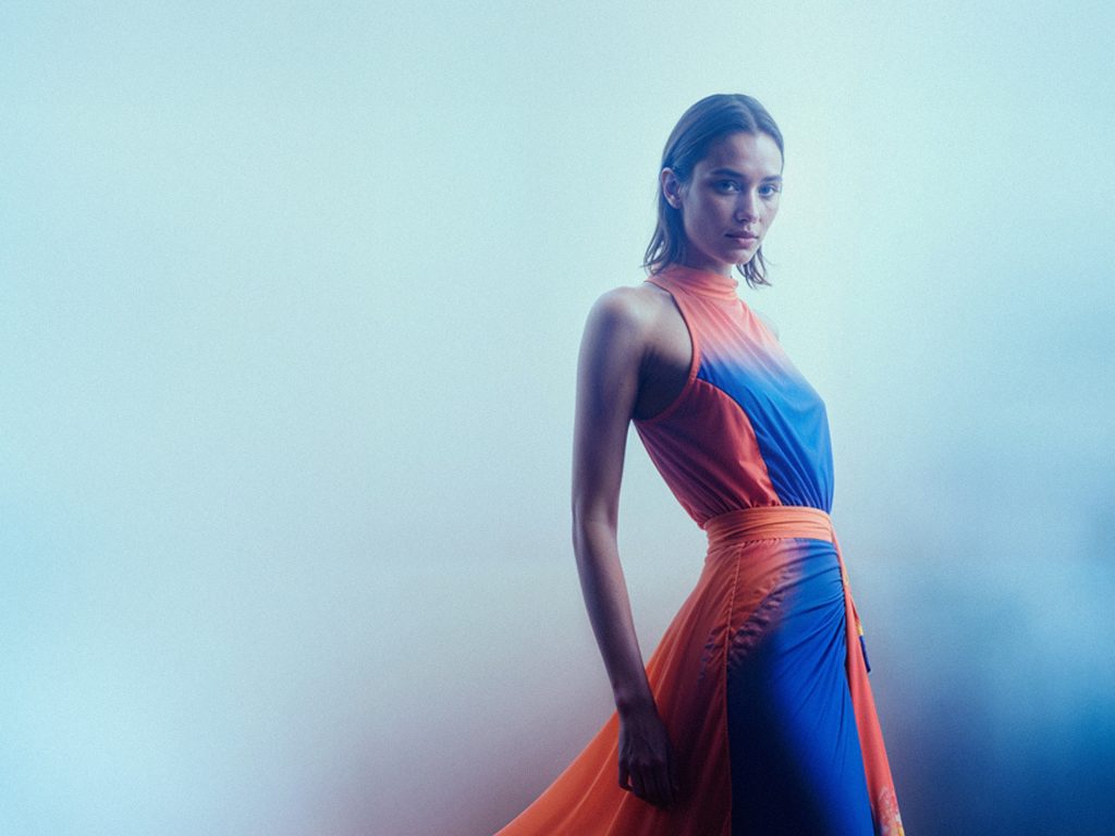 Fotografie einer Frau in einem orange-blauen Kleid, digital entworfen mit Digital Fashion und KI